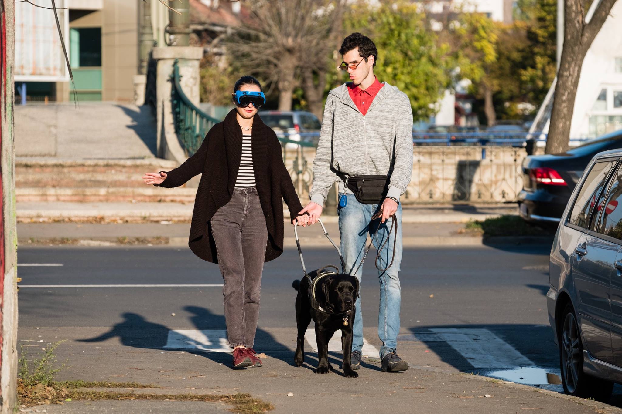 Descriere foto: Phantom pe strada ghideaza un participant cu ochelari, impreuna cu Paul. 