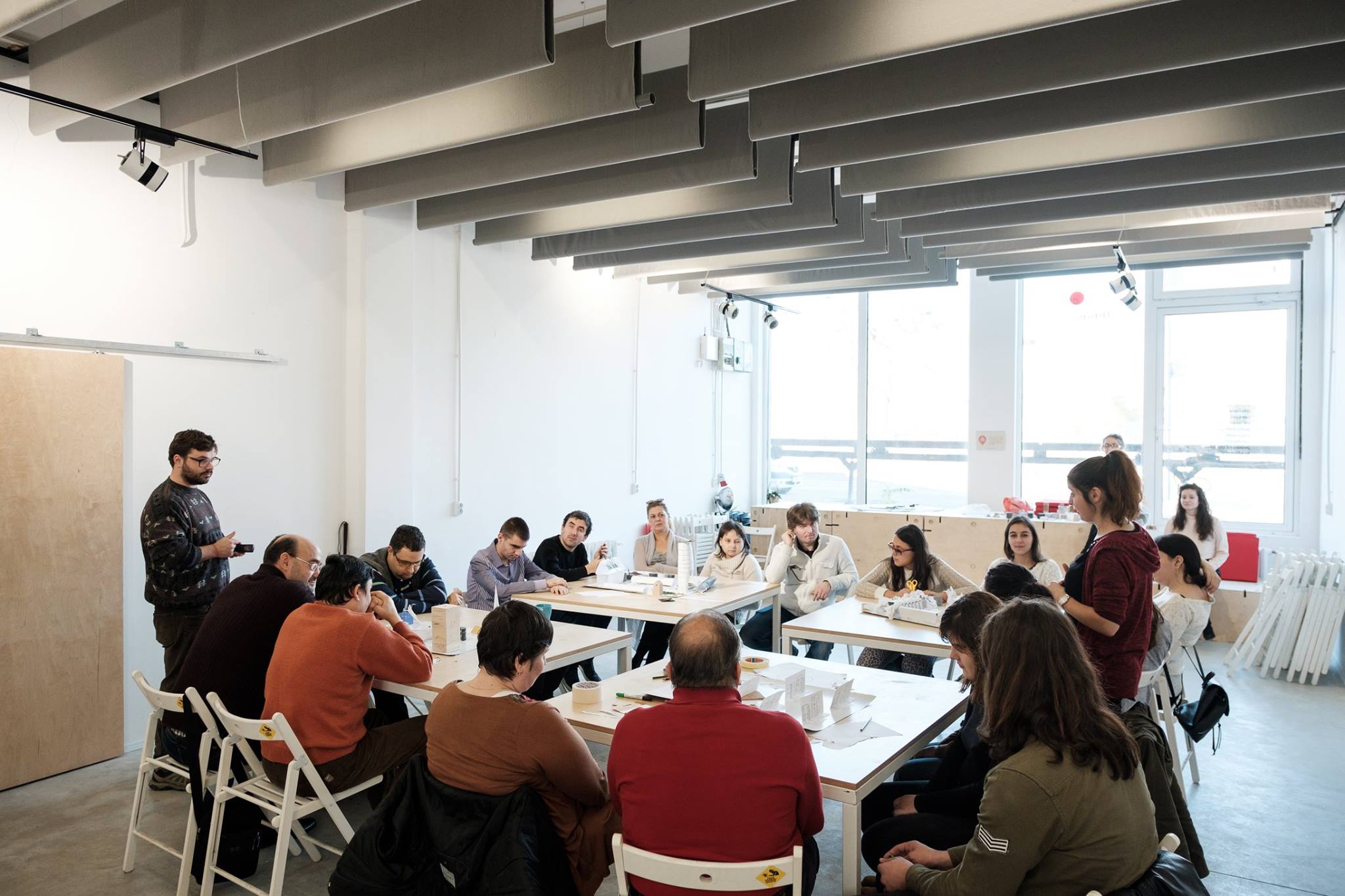 Descriere foto: participantii asezati la mesele de lucru unde fiecare echipa a creat orasul ideal. 